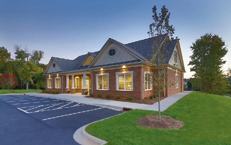 Picture of a professional office building with an empty parking lot in front